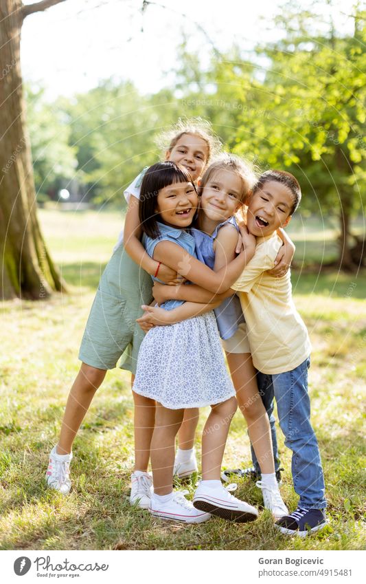 Group of asian and caucasian kids having fun in the park happy summer happiness smiling cheerful friends little friendship ethnicity togetherness girls boy