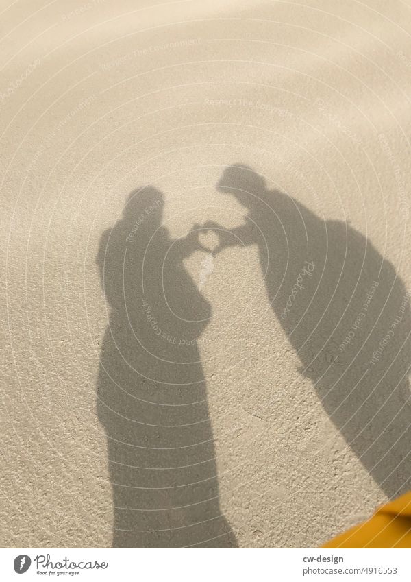 Couple in love on the beach shows a heart couple Heart Beach Sand Exterior shot Vacation & Travel coast Water Together Colour photo Relaxation Nature Summer