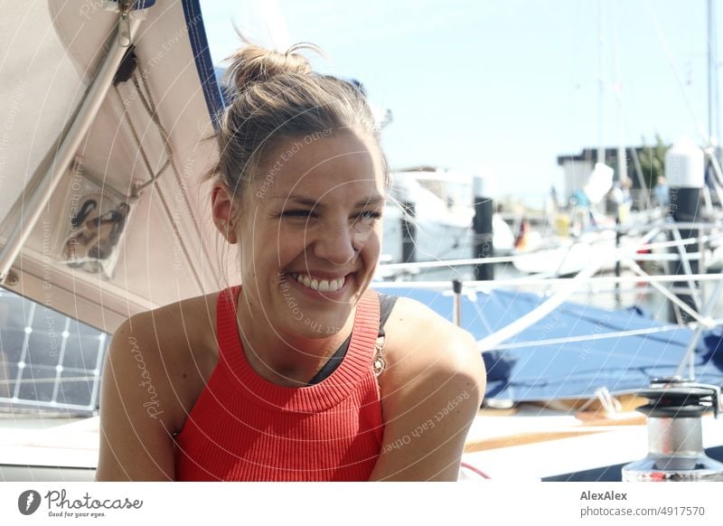 Young beautiful woman sitting on sailboat and smiling Lifestyle Back-light salubriously pretty Woman Athletic Slim Esthetic teen daintily Self-confident