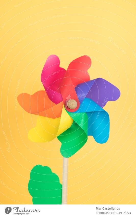 Coloured pinwheel on yellow background. Copy space. Vertical photo. vertical rainbow lgtbq standing copy space green toy children party decoration colour