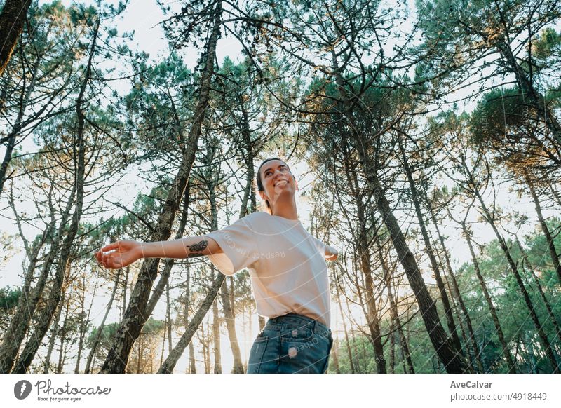 young woman breathing clean air in nature forest.Fresh outdoor, wellness healthy lifestyle concept. concept of trees for environment, global warming, healthy lifestyle, people in nature,no pollution