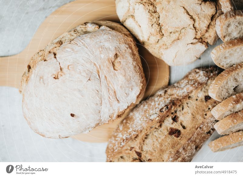 Different kinds types of freshly baked artisan and organic bread over a rustic table. Homemade cooking. Sourdough bread with crispy crust on wooden shelf. Bakery goods concept. Restaurant and goods