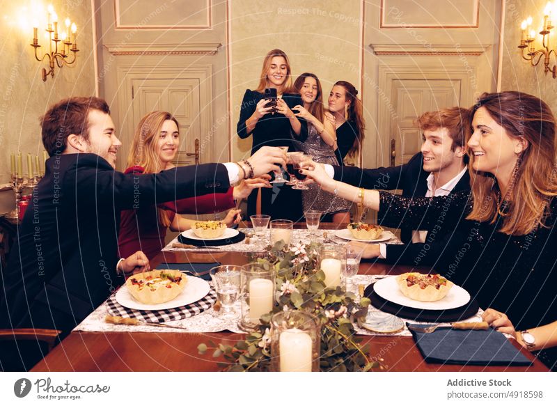 Friends clinking wineglasses in restaurant friend cheers group toast alcohol celebrate occasion dinner reunion meeting meal red wine selfie self portrait food