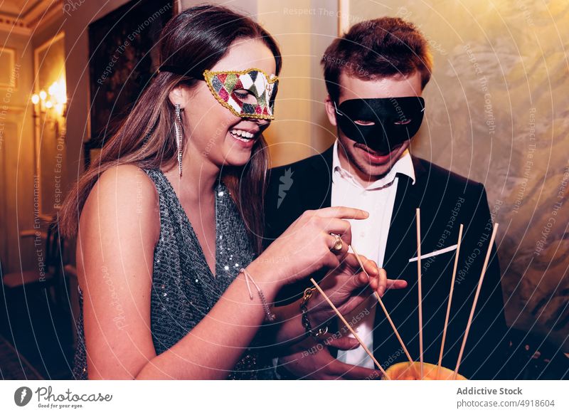 Couple in masquerade masks eating melon during party couple friend fruit ball celebrate occasion date food restaurant appearance festive gather bonding meeting