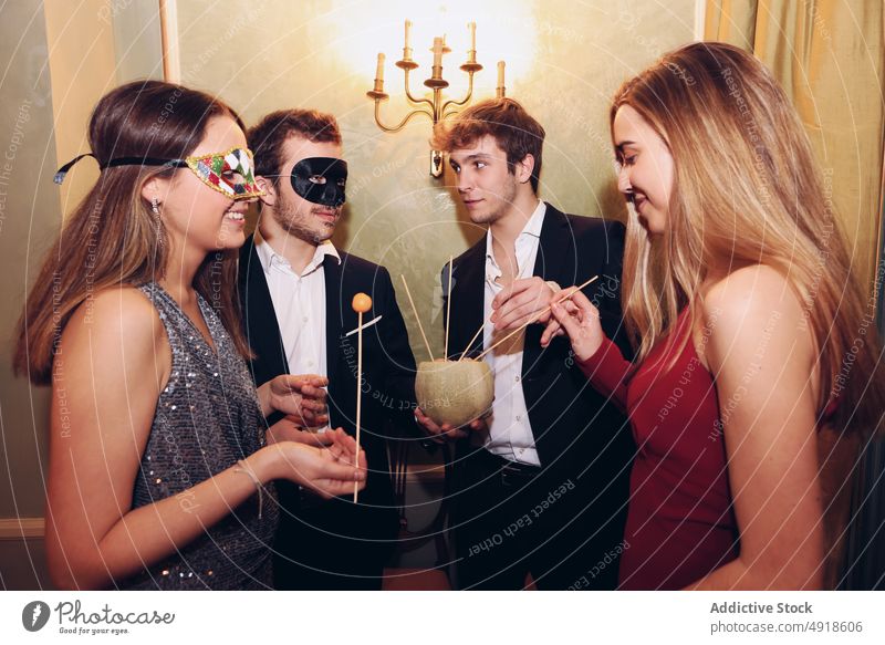 People in masquerade masks eating melon during party friend group fruit ball celebrate occasion food restaurant appearance festive gather bonding meeting