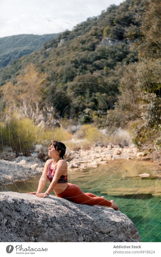 Woman practicing yoga in the river nature woman lifestyle female cobra pose lake healthy adult relaxation summer young exercise body beauty sport person girl