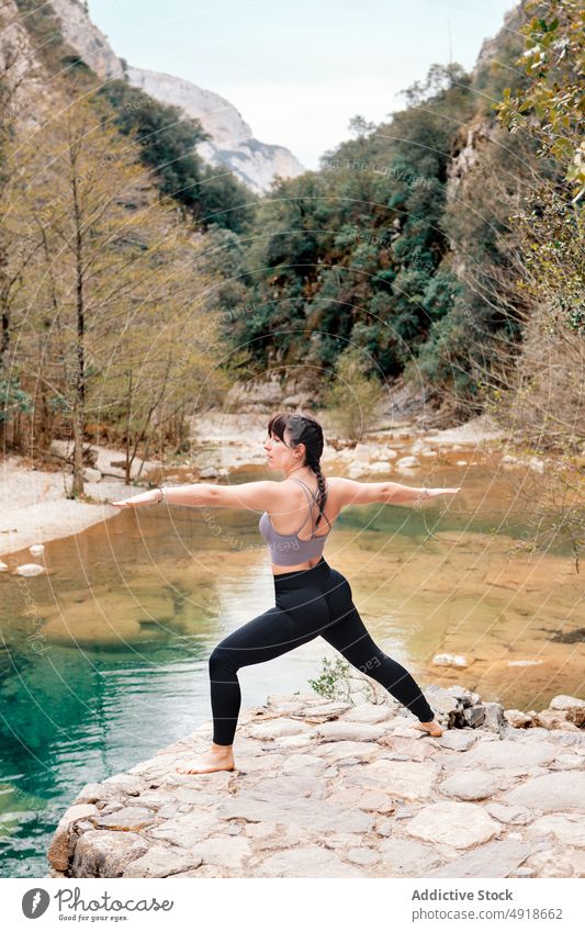Woman practicing yoga in the river nature woman lifestyle female lake healthy adult relaxation summer Warrior Pose young exercise body beauty sport person girl