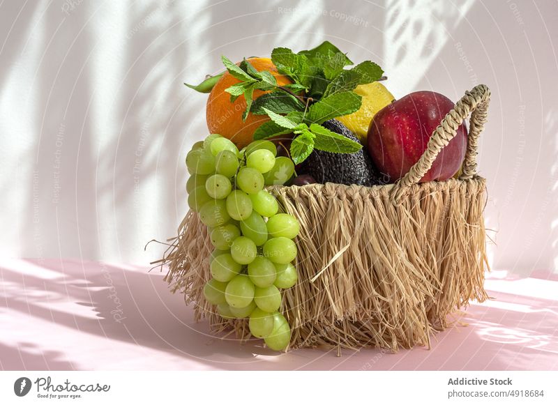 Fresh fruits in wicker basket grape mix vitamin healthy food orange apple mint natural assorted ripe leaf tasty fresh palatable nutrient appetizing colorful