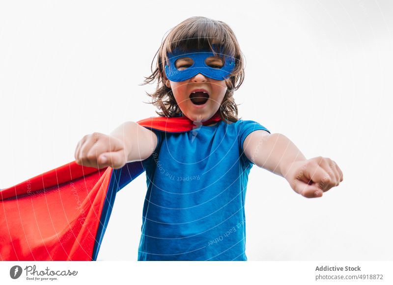 Strong little superhero clenching fists girl strong scream pretend play clench fist gray sky costume kid power courage brave aspiration strength child yell