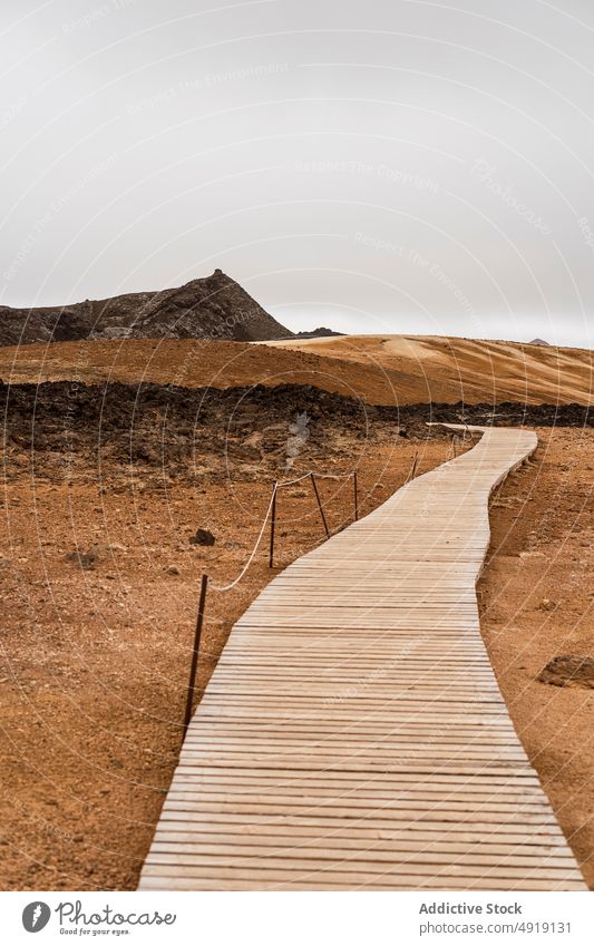 Empty boardwalk in volcanic valley under cloudy sky pathway mountain nature highland scenic picturesque peaceful ridge formation empty nobody iceland terrain