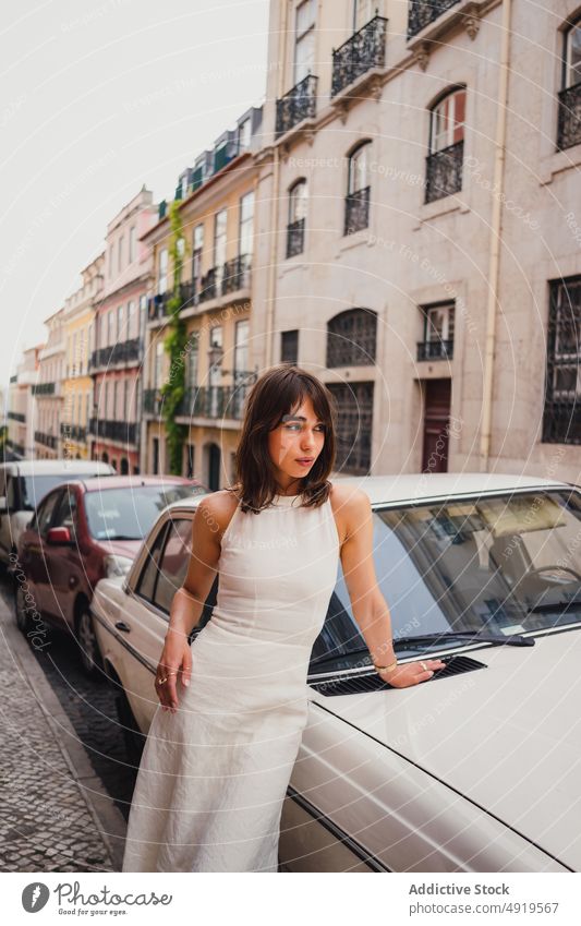 Woman near retro car in city woman street style old timer vintage dress parked building attire optimist shabby weathered nostalgia garment summer female