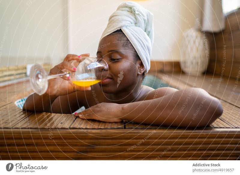 Black woman drinking a juice inside a jacuzzi spa black young female beauty relax lifestyle relaxation happy attractive luxury people leisure person wellness