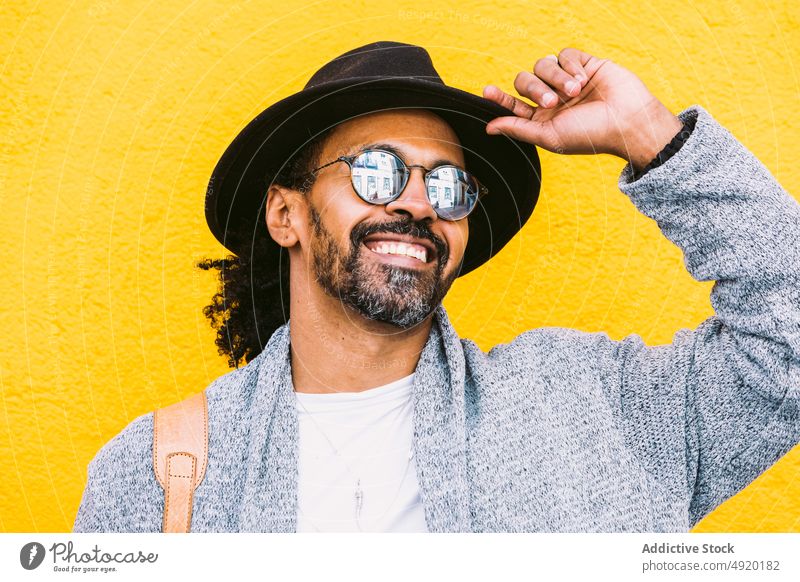 Happy Hispanic man against yellow wall street style happy laugh urban outfit appearance bright color male adult hispanic ethnic bag shoulder cheerful optimist