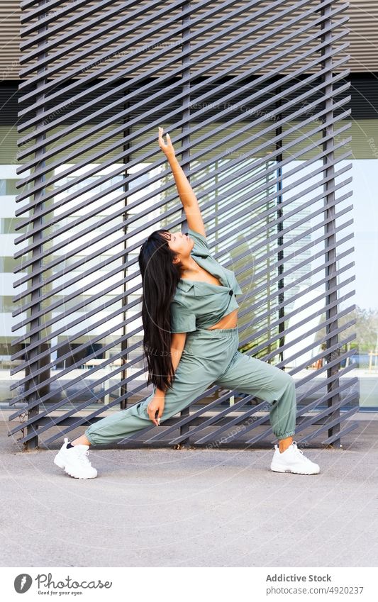Asian woman dancing on street dance urban lunge arm raised wall building modern perform female young ethnic asian long hair style dancer energy skill activity