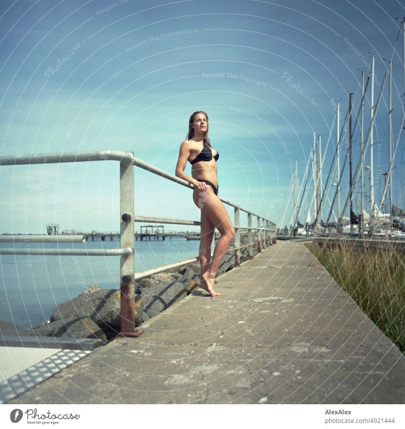 Analog medium format picture of young beautiful tall woman in bikini on the pier at the Baltic Sea Lifestyle salubriously pretty Woman Athletic Slim Esthetic