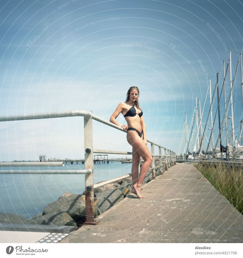 Analog medium format picture of young beautiful tall woman in bikini on the pier at the Baltic Sea Lifestyle salubriously pretty Woman Athletic Slim Esthetic