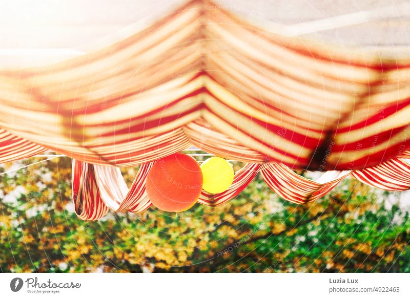 View from the window into the greenery, on a red wine striped awning and balloons red and yellow Sun blind Striped Red White red white striped Light Yellow