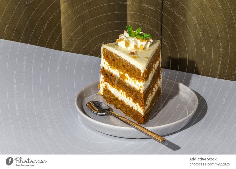 Slice of tasty carrot cake sweet dessert flavor confection treat slice pastry sponge indulge calorie yummy baked mint serve plate table spoon delicious food