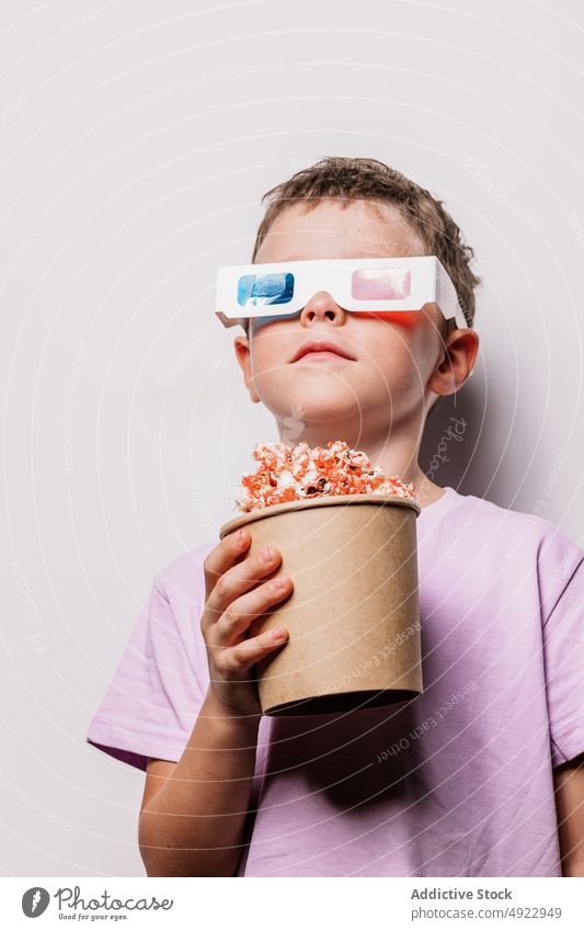 Boy in 3D glasses with popcorn child 3d boy kid entertain amusement movie cartoon snack interesting hobby shock vision treat imagination delicious tasty