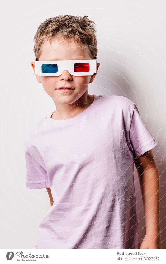 Smiling boy with colorful 3D glasses 3d kid smile entertain vision amusement childhood delight hobby happy cardboard casual studio optical adorable style
