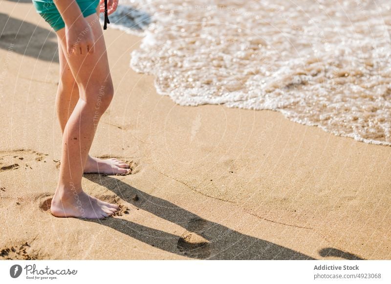 Unrecognizable kid walking on sandy beach leg sea coast summer barefoot shore resort wave getaria zarautz spain child water nature seaside ocean childhood