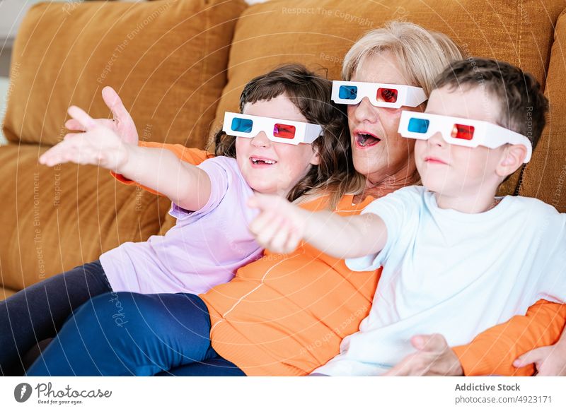 Mother with kids in 3D glasses watching movie at home mother children 3d showtime television entertain living room realistic girl spare time boy son daughter