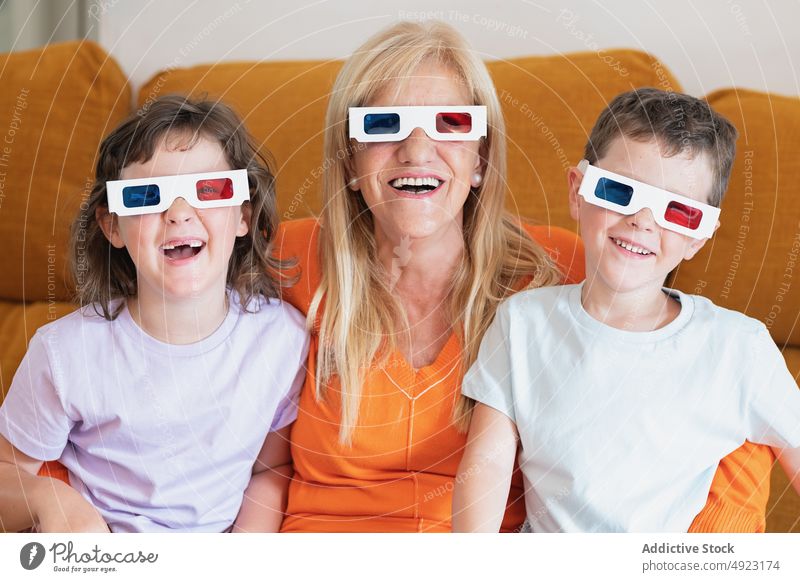 Mother with kids in 3D glasses watching movie at home mother children 3d smile happy showtime television entertain living room realistic girl spare time boy son