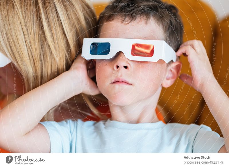 Boy putting on 3D glasses at home boy 3d put on movie kid showtime male entertain television realistic living room three dimensional free time prepare shock