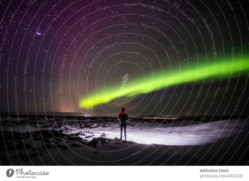 Traveler admiring aurora borealis in night sky northern light terrain traveler admire snow iceland starry green glow cold polar nature astronomy tourism winter