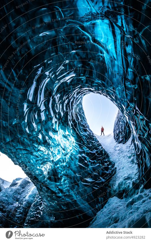 Explorer in ice cave in winter traveler explore frozen cold vacation adventure scenery iceland frost nature north tourist climate rock freeze wanderlust journey