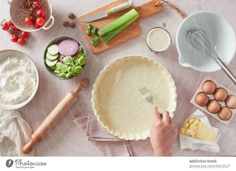 Crop woman poking holes in raw quiche case poke dough ingredient kitchenware fork female crust prepare cook pastry recipe organic milk dairy egg onion celery
