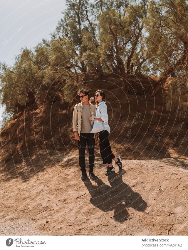 Young travelling couple admiring nature during vacation in desert admire together cuddle style hill love relationship sand trip adventure romantic young
