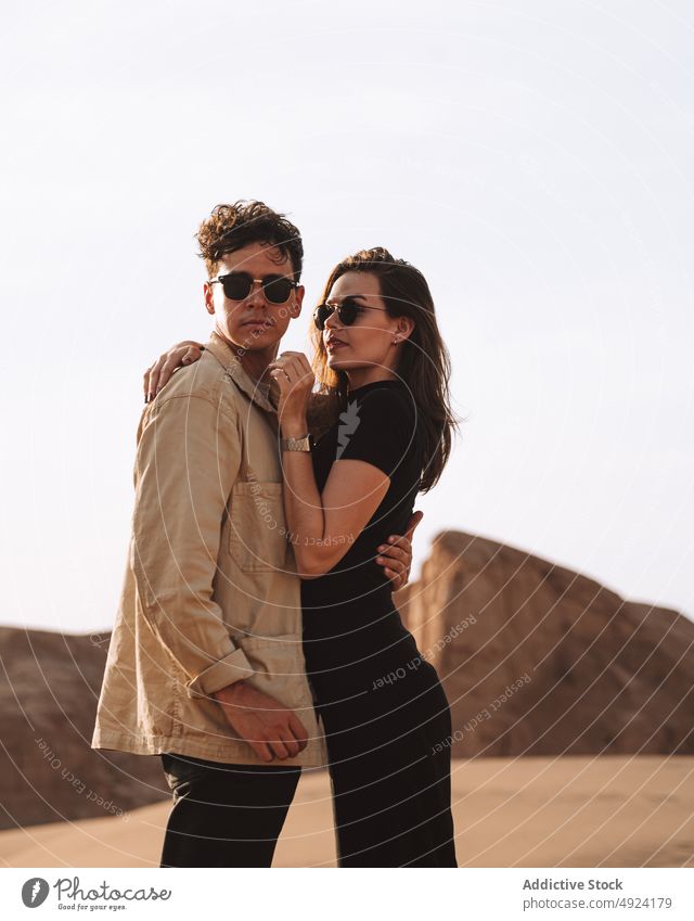 Happy traveling couple standing in desert trip smile love vacation traveler holiday together embrace relationship scenic boyfriend girlfriend young style