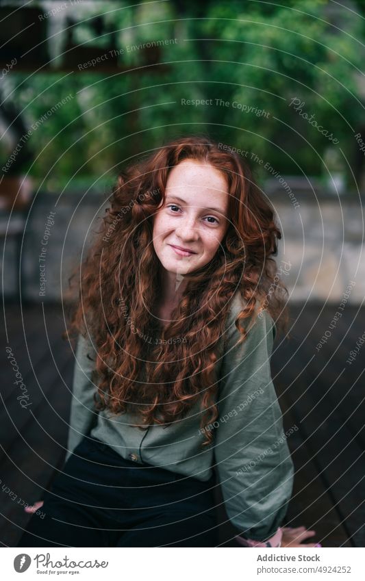 Happy redhead female sitting on floor and smiling woman smile portrait positive confident red hair freckle style glad shrub curly hair rest individuality