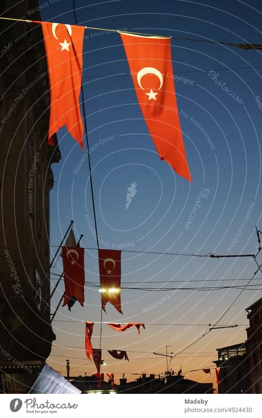 Red Turkish flags at night in the light of the street lights at the Galata quarter in the Istiklal Caddesi in the Beyoglu district of Istanbul on the Bosporus in Turkey