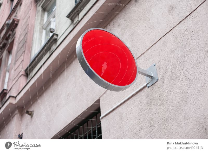 Round billboard mockup image. Red round store sign for logo mock up. Shop sign on grey old building in the street. blank red branding sale shop symbol web