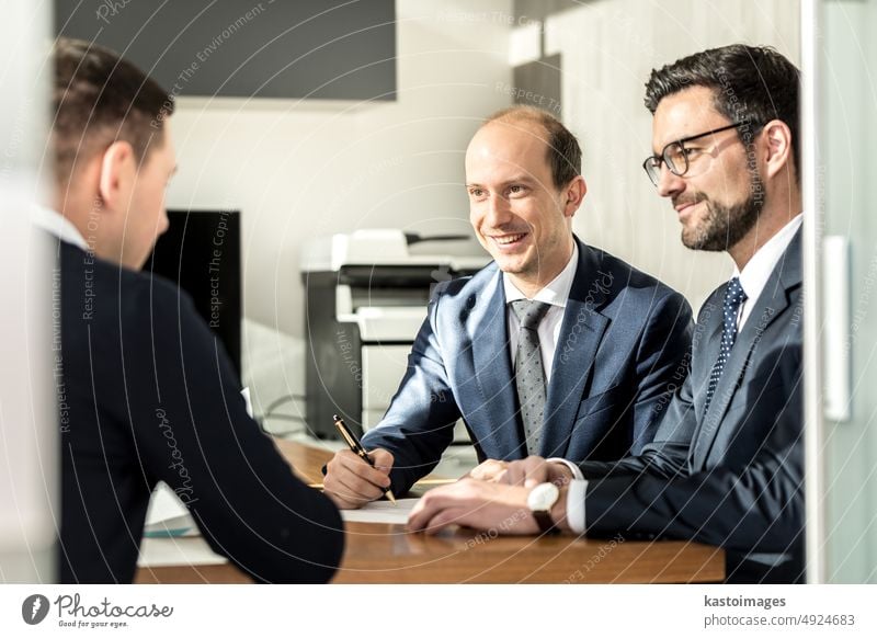 Group of confident successful business people reviewing and signing a contract to seal the deal at business meeting in modern corporate office. professional