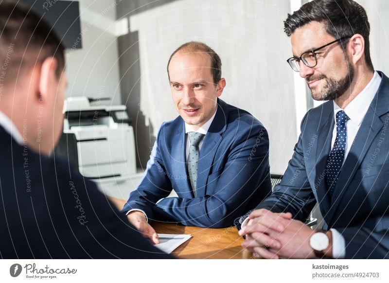 Team of confident successful business people discussing the contract terms at business meeting in modern corporate office. professional document work agreement