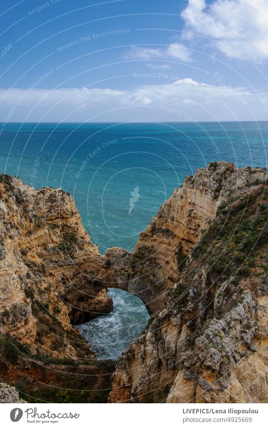 Beautiful cliff formation on the ocean's coast in various blue colors Algarve Atlantic backgrounds clouds copy space day daylight detail environment europe