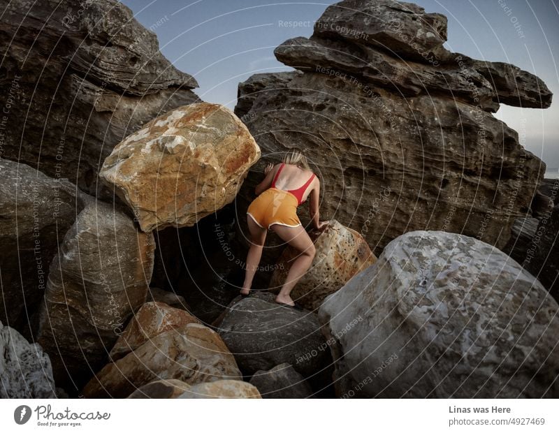 Some huge rocks are perfect for a gorgeous blonde girl to climb. On a holidays in Vietnam, Phu Quoc Island. Dressed in yellow shorts and red swimsuit you can see her sexy curves and muscles. It’s not about sports though.