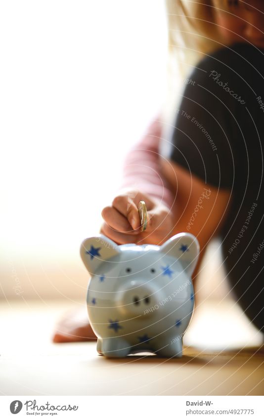 Girl with piggy bank - throwing euro into piggy bank Child Money box Save coin Euro concept Parenting Future Hand Forward-looking