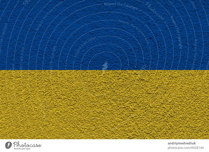 Ukrainian state national flag. Texture concrete grunge wall in yellow-blue color. State symbol of Ukraine and Ukrainians. Ukrainian flag on a concrete wall background.