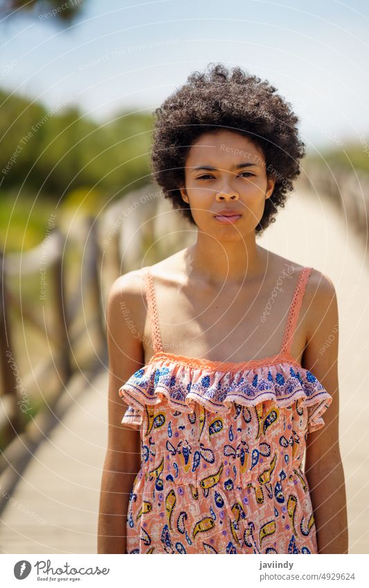 Young black woman on sunny summer day tourist rest boardwalk resort calm weekend portrait holiday female young african american ethnic sunlight style relax