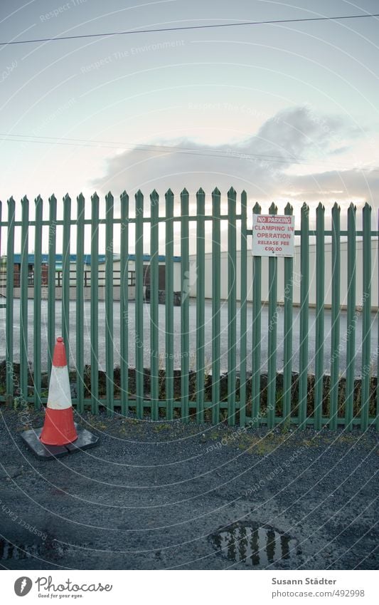 A o Industrial plant Street Lanes & trails Gloomy Town Divide Fence Fence post Traffic cone Road sign Puddle Pylon Colour photo Exterior shot Deserted Dawn