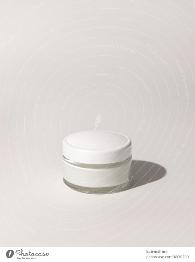 Cosmetic jar with a lid on white close up, mockup. Everyday skincare routine cream cosmetics hard shadow negative space copy space Brand packaging natural label