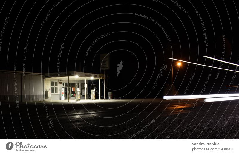 a vacant rural petrol station at night with car light trails Night scene Sandra Prebble garage southland petrol pump empty uninhabited lonely dark
