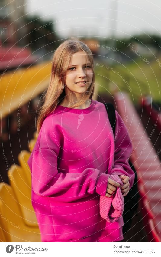 Portrait of a teenage student looking into the camera, against the background of the school stadium girl backpack schooltime teenager education female portrait