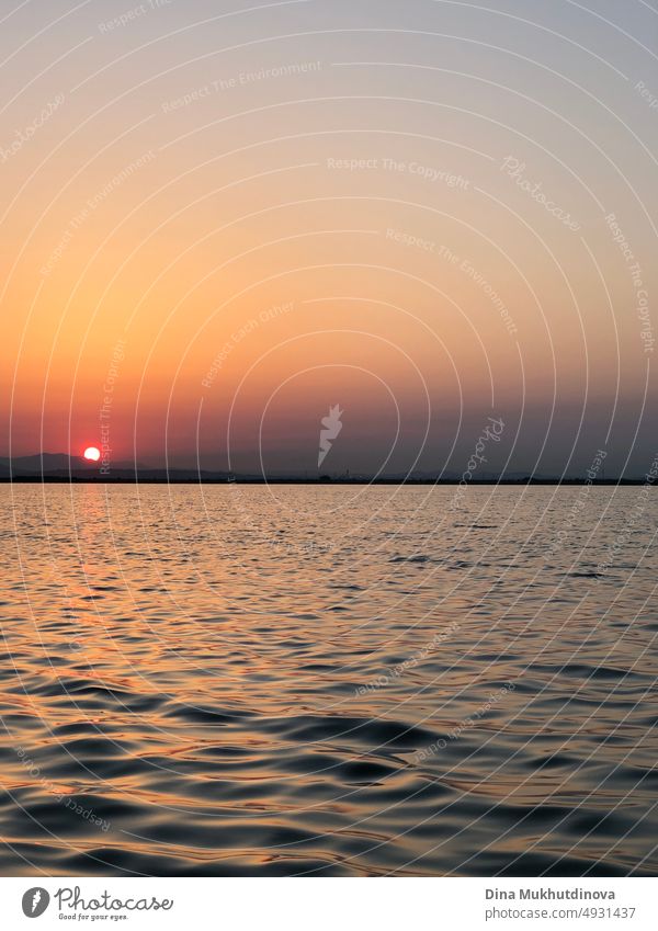 Beautiful sunset over the lake, view from a boat. Sun setting over the mountains. Ripples on water. outdoor peak hiking leisure sunrise season outdoors beauty