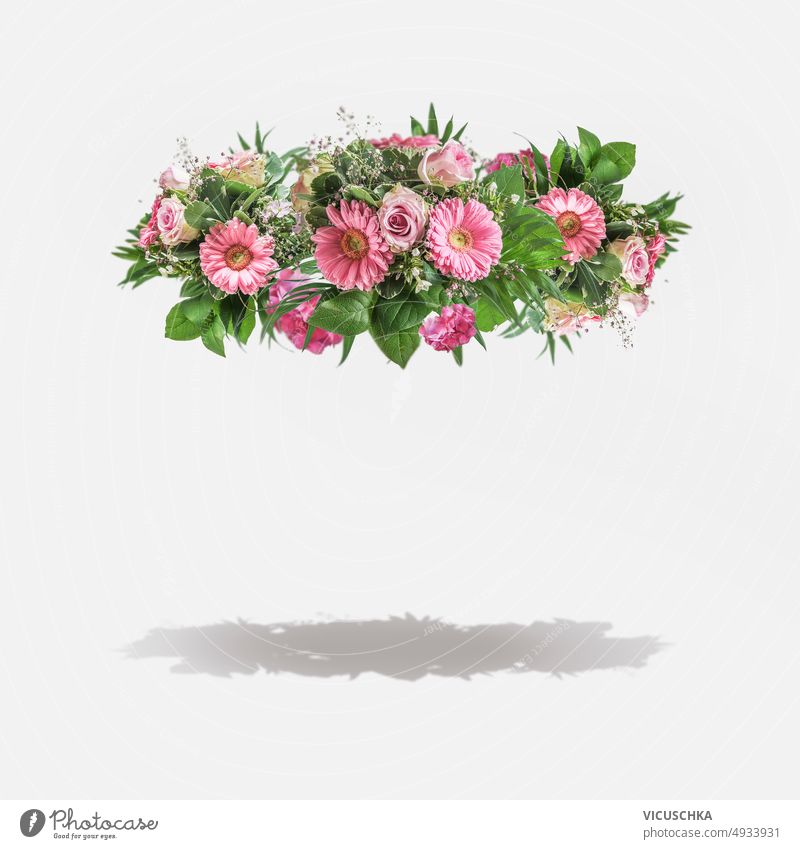 Flying floral garland with pink flowers and green leaves at white background with shadow. flying frame daisies gerbera branch abstract beauty romantic leaf rose