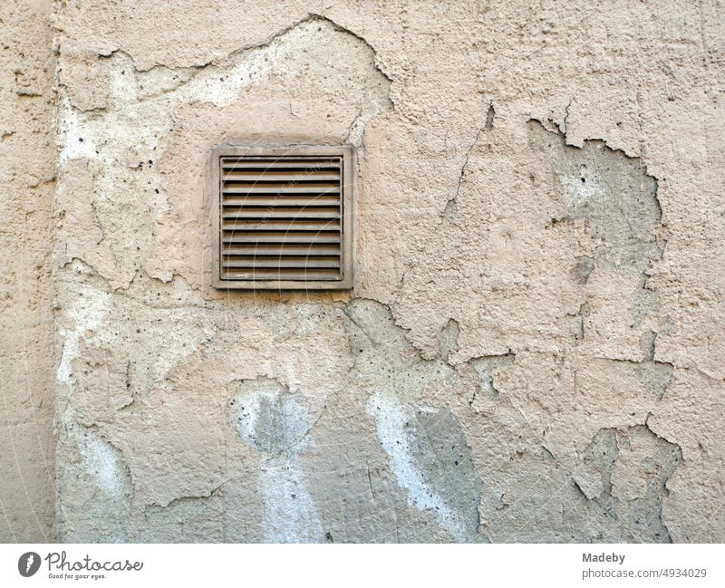Square ventilation grille in a crumbling facade in natural colours in the old town of Oerlinghausen near Bielefeld in the Teutoburg Forest in East Westphalia-Lippe